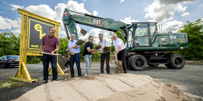 fünf Männer schippen Sand