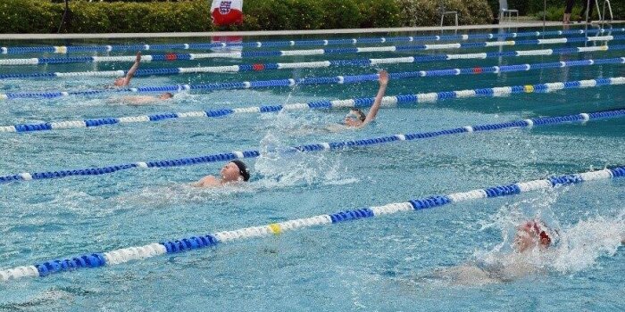 In einem Schwimmbecken schwimmen mehrere Kinder um die Wette.