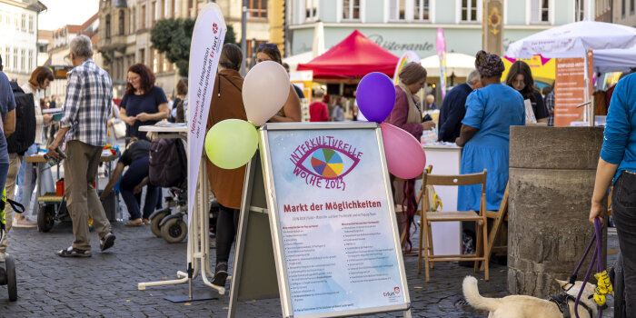 Auf einem Platz sind viele Menschen unterwegs.