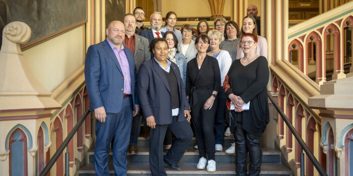 Gruppenfoto mit 15 Personen auf einer Treppe