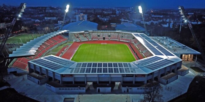 Luftaufnahme eines Stadions bei Nacht mit Flutlicht