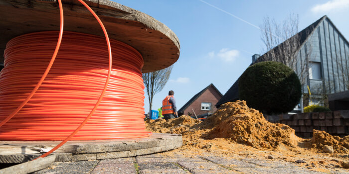 Foto: Ausbau des Glasfasernetzes © Deutsche Glasfaser eine Kabelrolle, im Hintergrund eine Baustelle