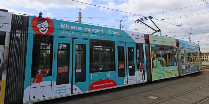 Eine Straßenbahn ist beklebt mit Werbung für die Erfurter Engagement-Agentur Erna. 