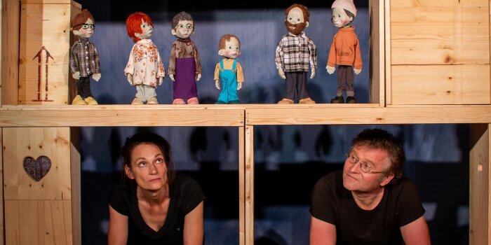 zwei Personen mit sechs Figuren eines Puppentheaters