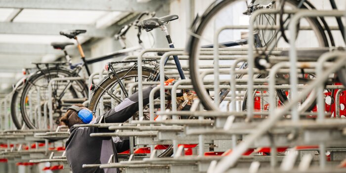 Foto: Sanierung des Radhauses am Bahnhof © Steve Bauerschmidt eine Person führt Arbeiten zwischen abgestellten Fahrrädern aus