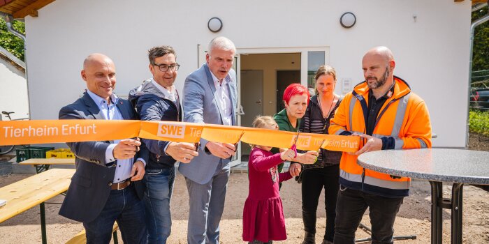 Foto: Neues Betriebsgebäude für Erfurter Tierheim © Stadtwerke Erfurt Vier Männer, zwei Frauen und ein Kind durchschneiden ein Band