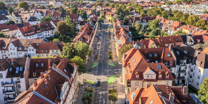 Eine Luftbildaufnahme zeigt die neue Gestaltung der Clara-Zetkin-Straße als einspurige Straße mit Begrünung.