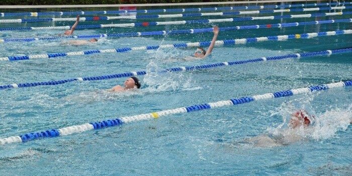 In einem Schwimmbecken schwimmen mehrere Kinder um die Wette.