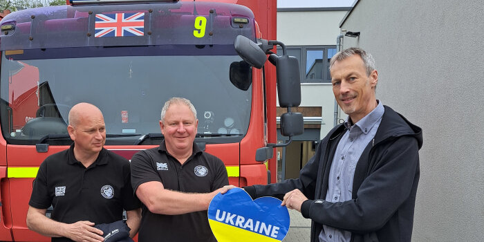 Zwei Männer halten ein blau-gelbes Herz mit der Aufschrift "Ukraine".