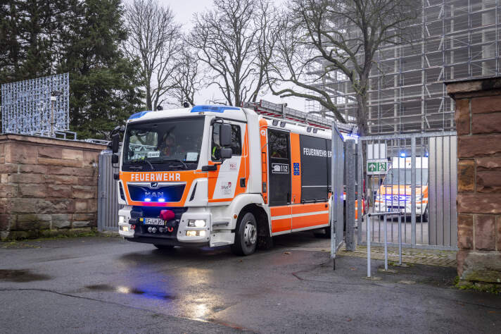 Ein Feuerwehrfahrzeug passiert ein eisernes Tor.