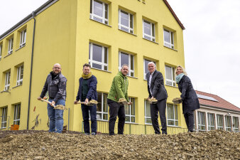 fünf Personen schippen mit einem Spaten