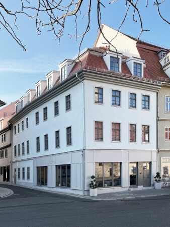 Ein großes Eckhaus mit heller Fassade