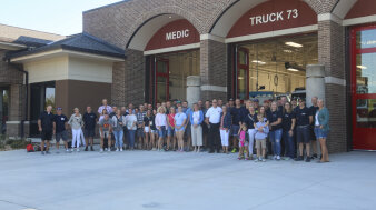 eine große Gruppe Menschen steht vor einer amerikanischen Feuerwache