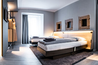 Ein Zimmer mit zwei Betten und viel indirektem Licht