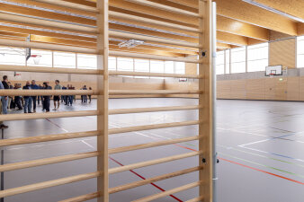 Innenraum einer Sporthalle mit Sprossenwand im Vordergrund