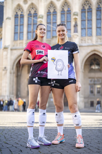 Zwei Frauen in Volleyball-Trikots zeigen eine gemalte Puffbohne.