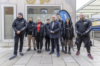 acht Personen, von denen einige schwarze Jacken mit Aufschrift "Nachteulen" tragen