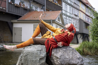 Till Eulenspiegel sitzt auf einem Stein vor der Krämerbrücke 
