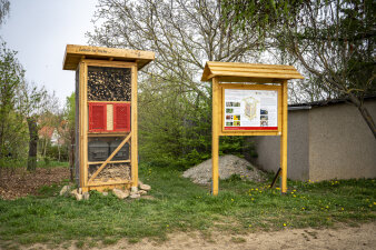 ein großes Insektenhotel und eine Informationstafel aus Holz