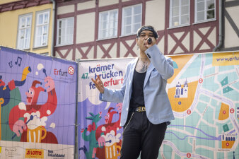 Ein Mann mit Mikrofon vor einer Leinwand
