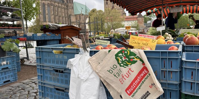 gestapelte Kisten mit Obst und Gemüse auf dem Markt mit Stoffbeuteln