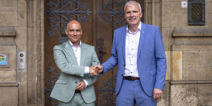 Foto: Amtsübergabe an den neuen Oberbürgermeister © Stadtverwaltung Erfurt Zwei Herren stehen vor einem Portal und geben sich die Hände.