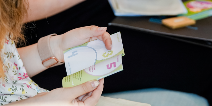 Kinderhände halten eine kleines Heftchen in der Hand