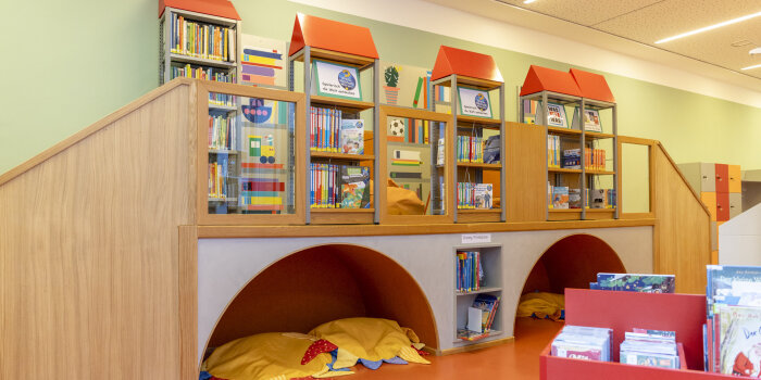 Der Nachbau einer Brücke steht als begehbares Bücherregal auf einem Gang. 
