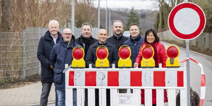 Eine Gruppe von personen stehen an einer Straßenabsperrung