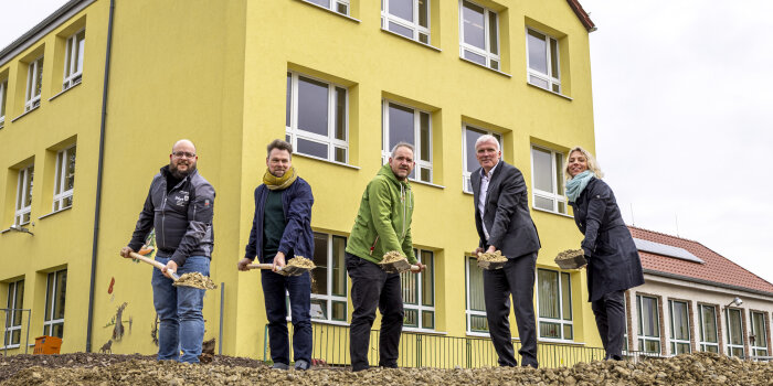 fünf Personen schippen mit einem Spaten