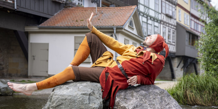 Till Eulenspiegel sitzt auf einem Stein vor der Krämerbrücke 