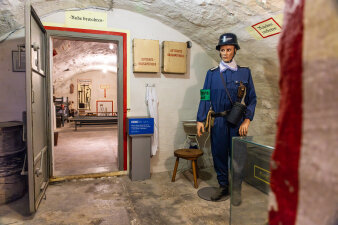ein museal hergerichteter Gewölbekeller, im Vordergrund eine Puppe im blauen Overall mit Helm