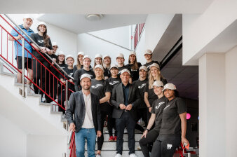 eine Gruppe vorwiegend schwarz gekleideter Menschen, zum Großteil Frauen, steht zum Gruppenfoto auf einer Treppe