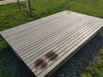 Eine Sitzbank aus Holz mit angekokelten Stellen 