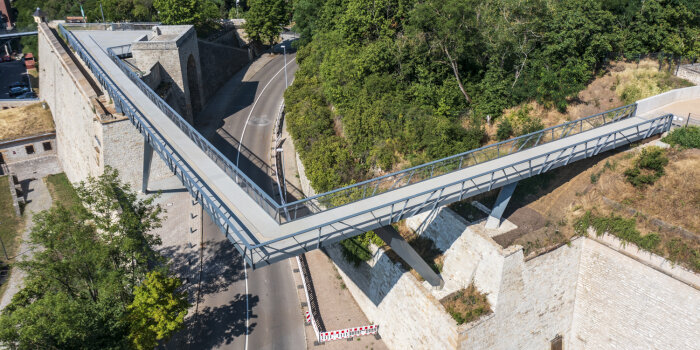 Luftansicht einer filigranen Stahlbrücke mit abgeknicktem Verlauf