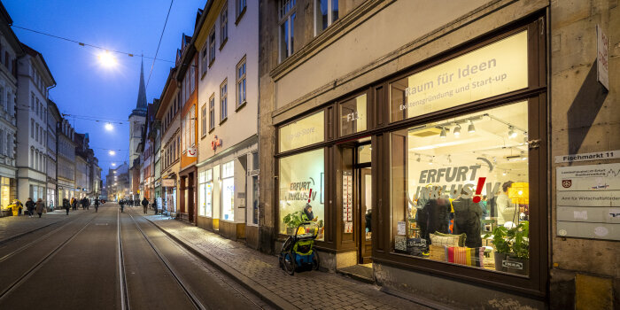 eine Straße in der Altstadt mit Geschäften, im dunkeln, die Schaufenster sidn beleuchtet