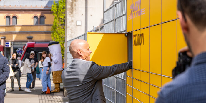 Ein Mann öffnet ein Fach einer Packstation