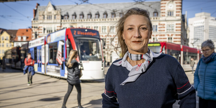 Foto: Bewerbertag Evag © Jacob Schröter Eine Frau in Dienstkleidung steht auf einem Platz in der Innenstadt, im Hintergrund Straßenbahnen