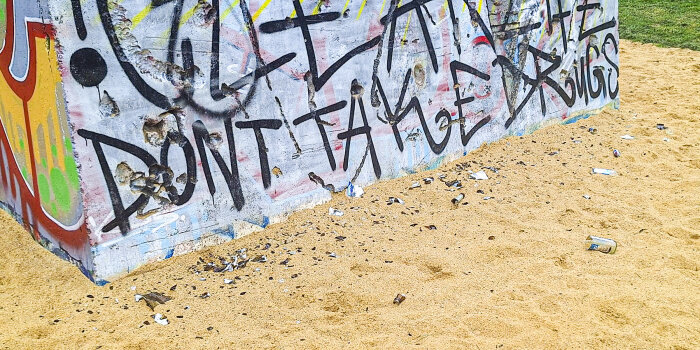 Sandkastenauf einem Spielplatz, im Sand liegen Glasscherben einer zerbrochnen Flasche