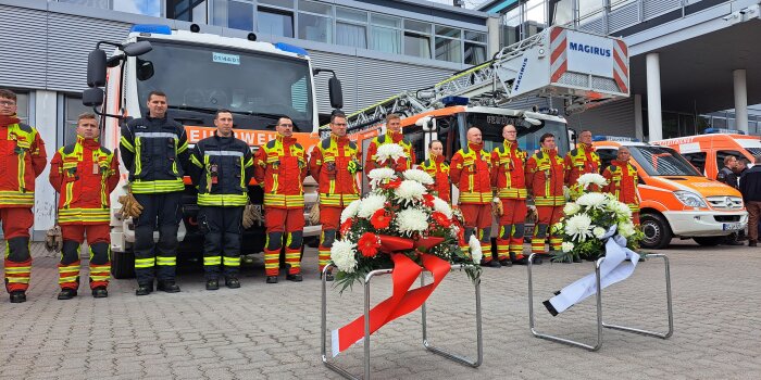 Viele Männer in Uniform stehen vor einem Gebäude und sind in Gedenkpose. 