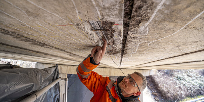 Foto: Einzelne Spanndrähte wurden freigelegt und entnommen, um sie im Labor zu untersuchen. © Stadtverwaltung Erfurt Mann der Brückenteile untersucht
