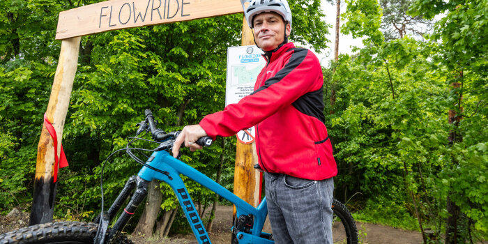 Foto: Eröffnung MTB Trail © Stadtverwaltung Erfurt An Mann steht mit Fahrrad und Helm an einem Waldstück