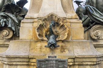 Ein üppig verzierter Brunnen aus Stein mit verschiednenen Skulpturen