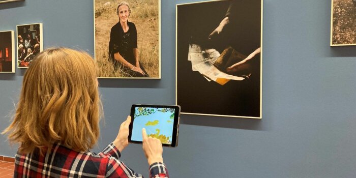 Foto: Kunstpädagogische Angebote in der Kunsthalle © Stadtverwaltung Erfurt/Sarah Hertam Jemand steht mit einem Tablet vor Fotografien
