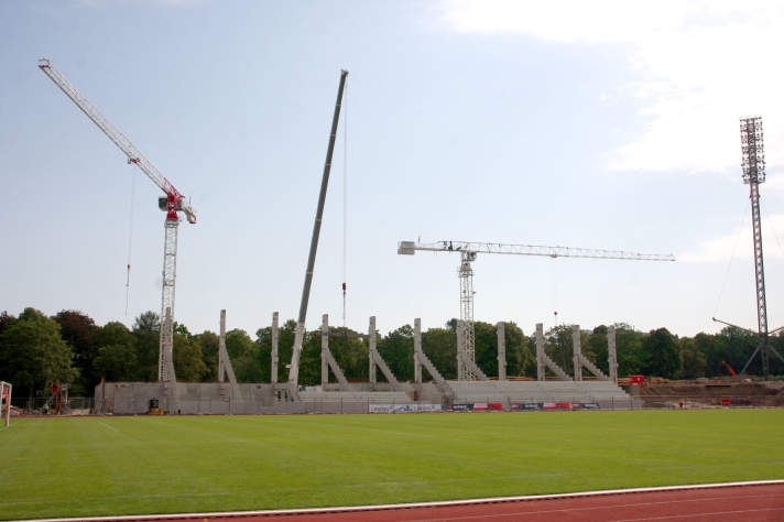 Stadionbaustelle mit 3 Kränen am Rohbau einer Tribüne