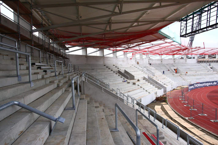 Überdachte Stehplatzränge eines Stadions.