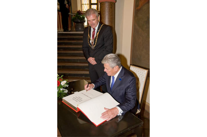 Der Bundespräsident trägt sich in das Goldene Buch der Stadt Erfurt ein, neben ihm stehend der Erfurter Oberbürgermeister.