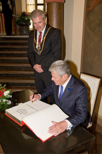 Der Bundespräsident trägt sich in das Goldene Buch der Stadt Erfurt ein, neben ihm stehend der Erfurter Oberbürgermeister.