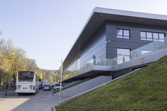 Das Foto zeigt in der rechten Hälfte die moderne Außenfassade des Steigerwaldstadions, links daneben steht der Mannschaftsbus der deutschen Frauen Nationalelf.