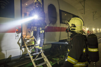 Einsatzkräfte der Feuerwehr verschaffen sich einen Überblick an der Tür zum ICE-Waggon